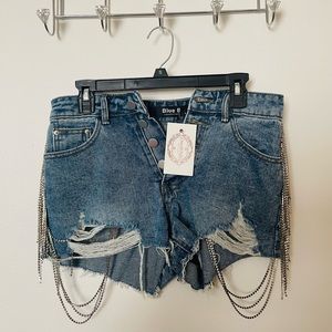 Super cute denim shorts with silver shiny tassels.